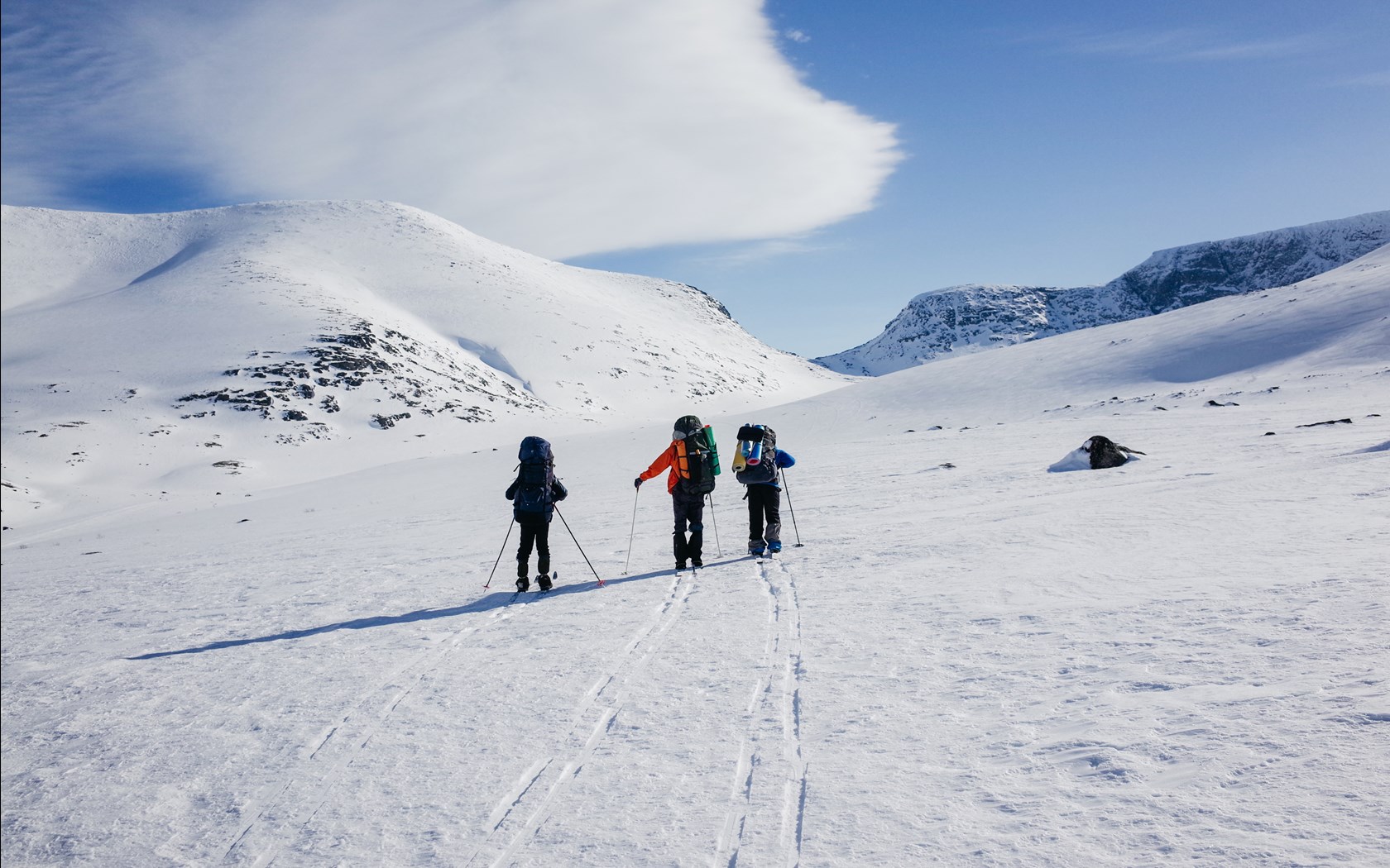 En gruppe på fjellskitur i slakt terreng.
