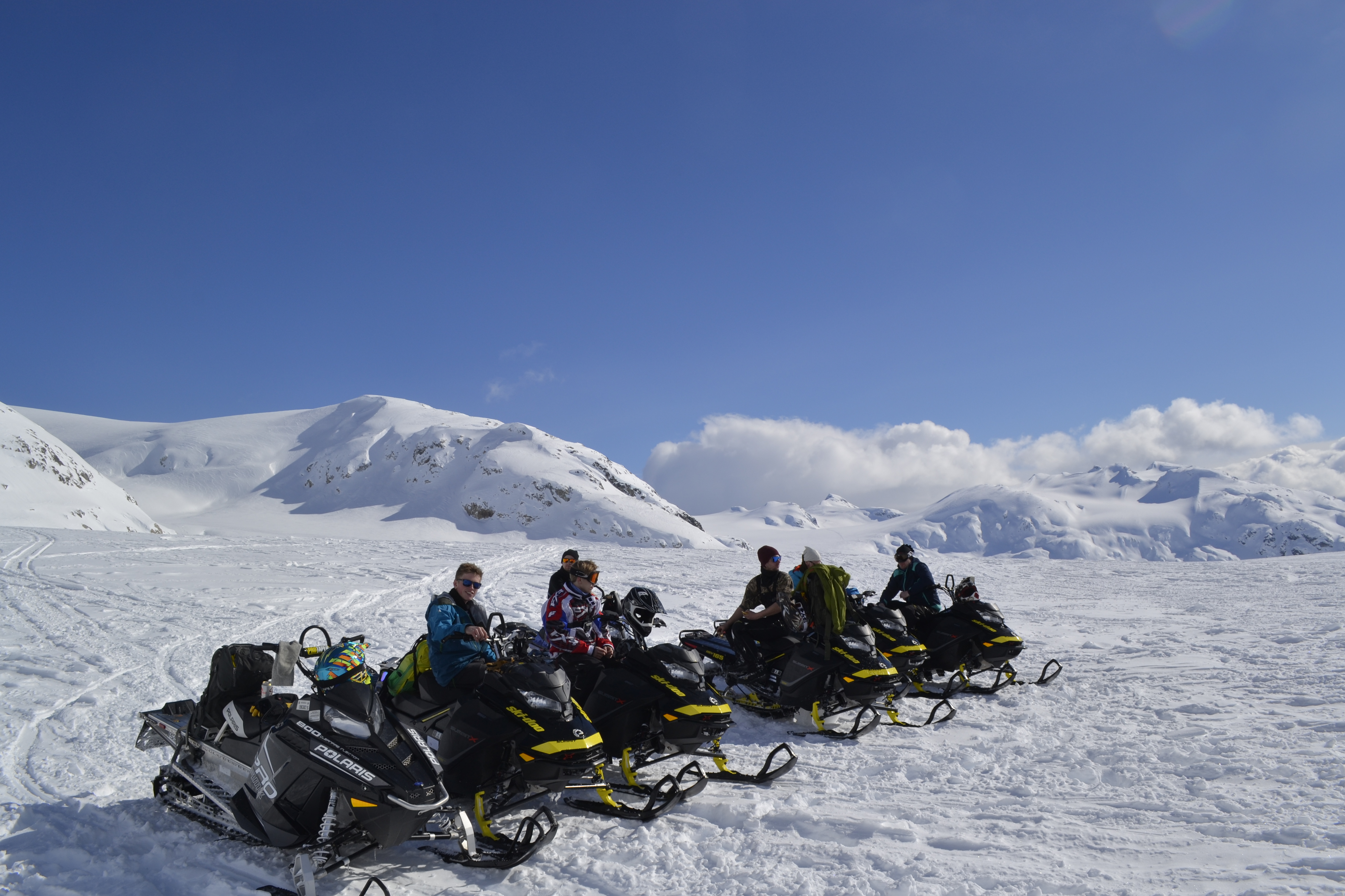 En gruppe snøskuterførere på fjellet.