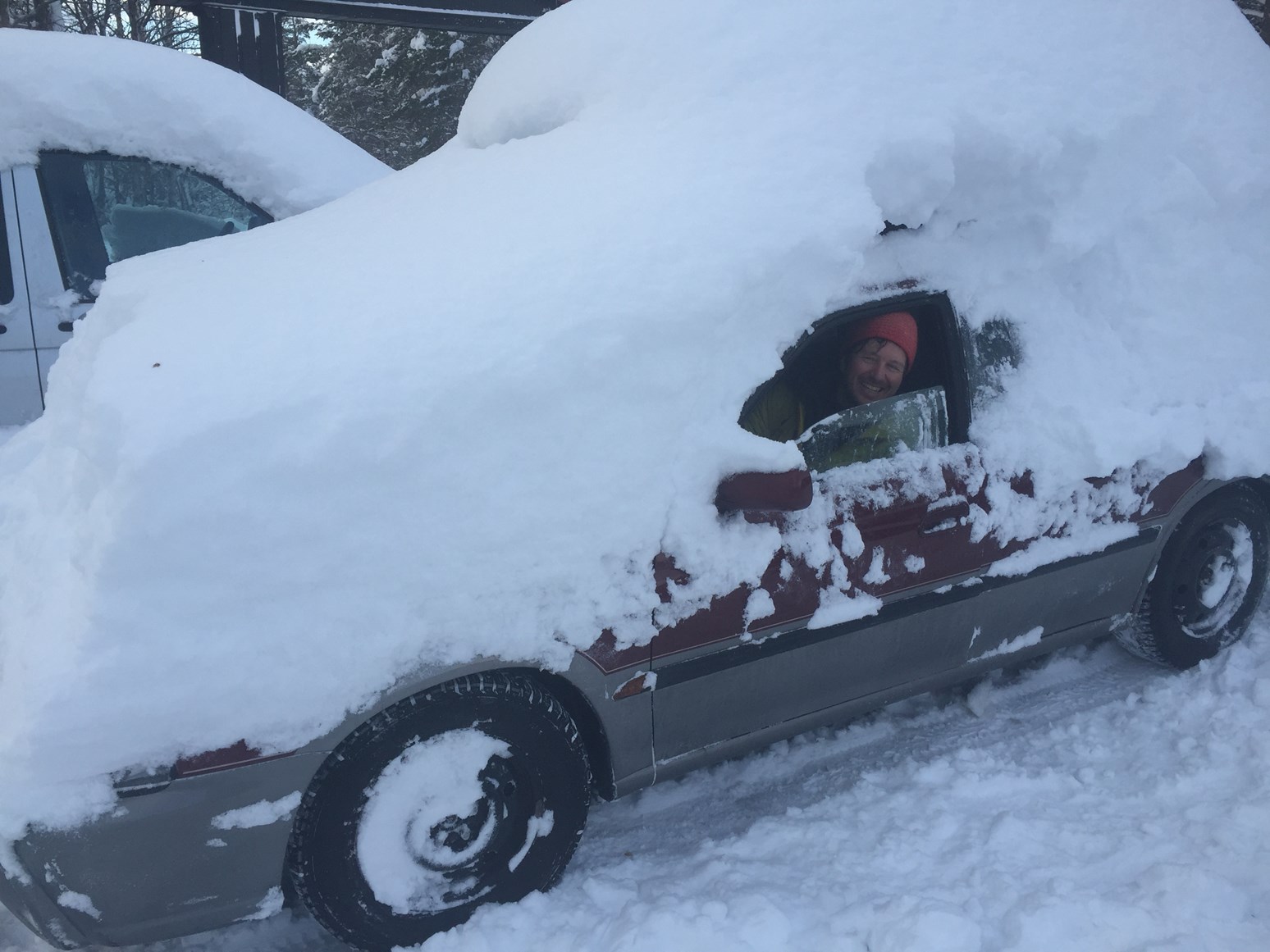 Bilde av en nedsnødd bil etter stort snøfall.