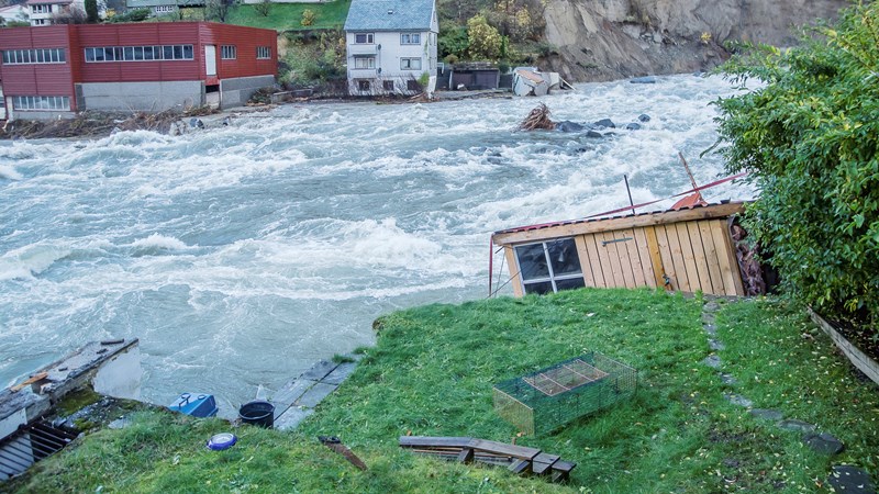 Flom i elv som har dratt med seg bygninger.