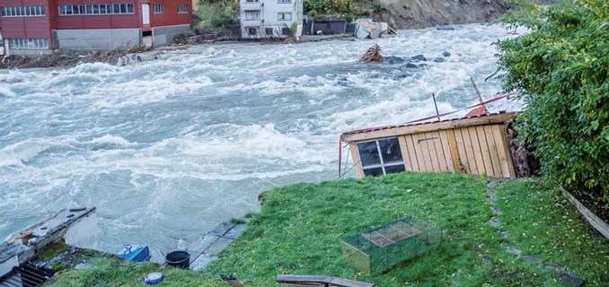 Flom i elv som har dratt med seg bygninger.