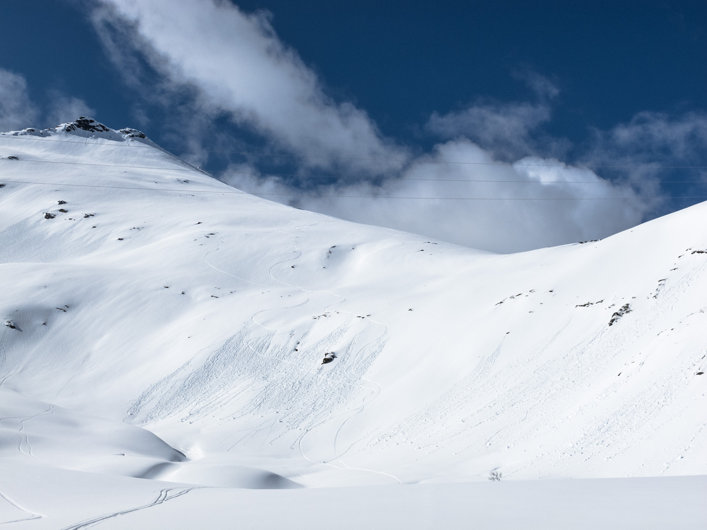 En fjellside hvor det har løsnet våt løssnø som følge av soloppvarming av steiner og omkringliggende snø.